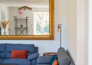 Salon lumineux d’une location saisonnière avec cuisine ouverte et table en bois