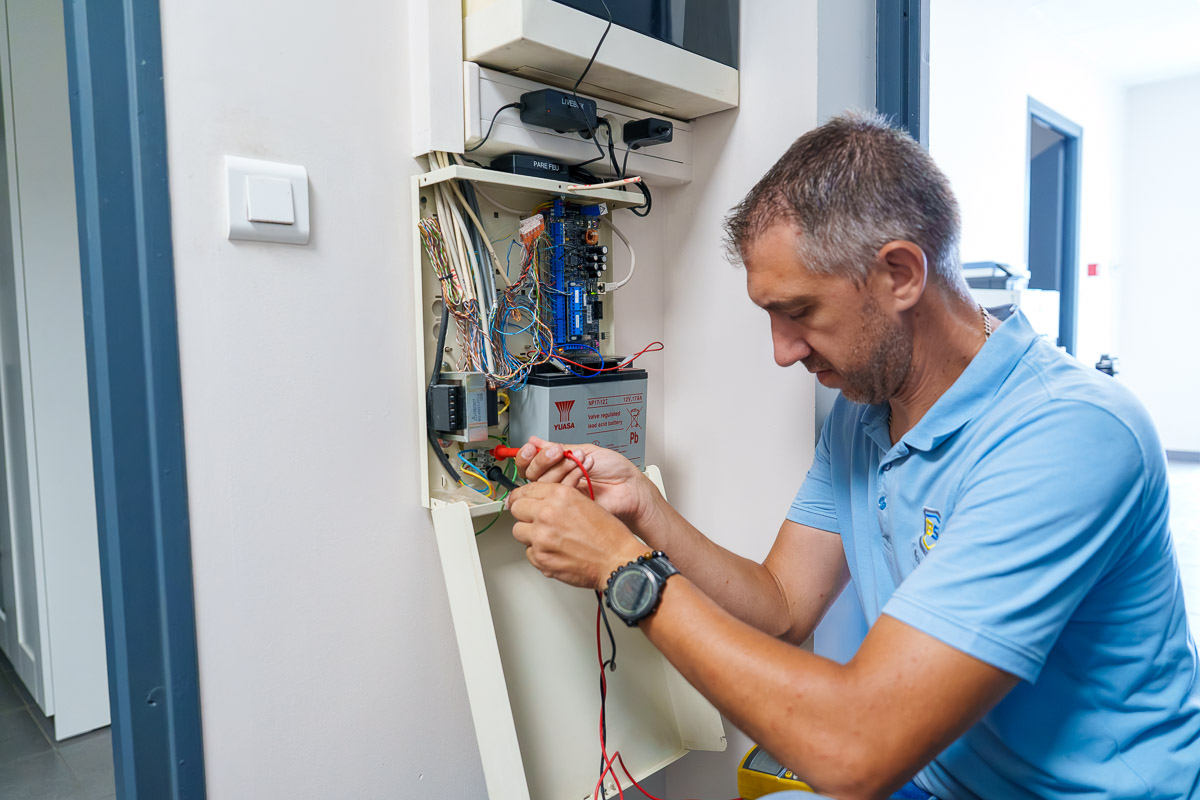 Technicien BS Solutions intervenant sur le câblage d’une centrale d’alarme ouverte.